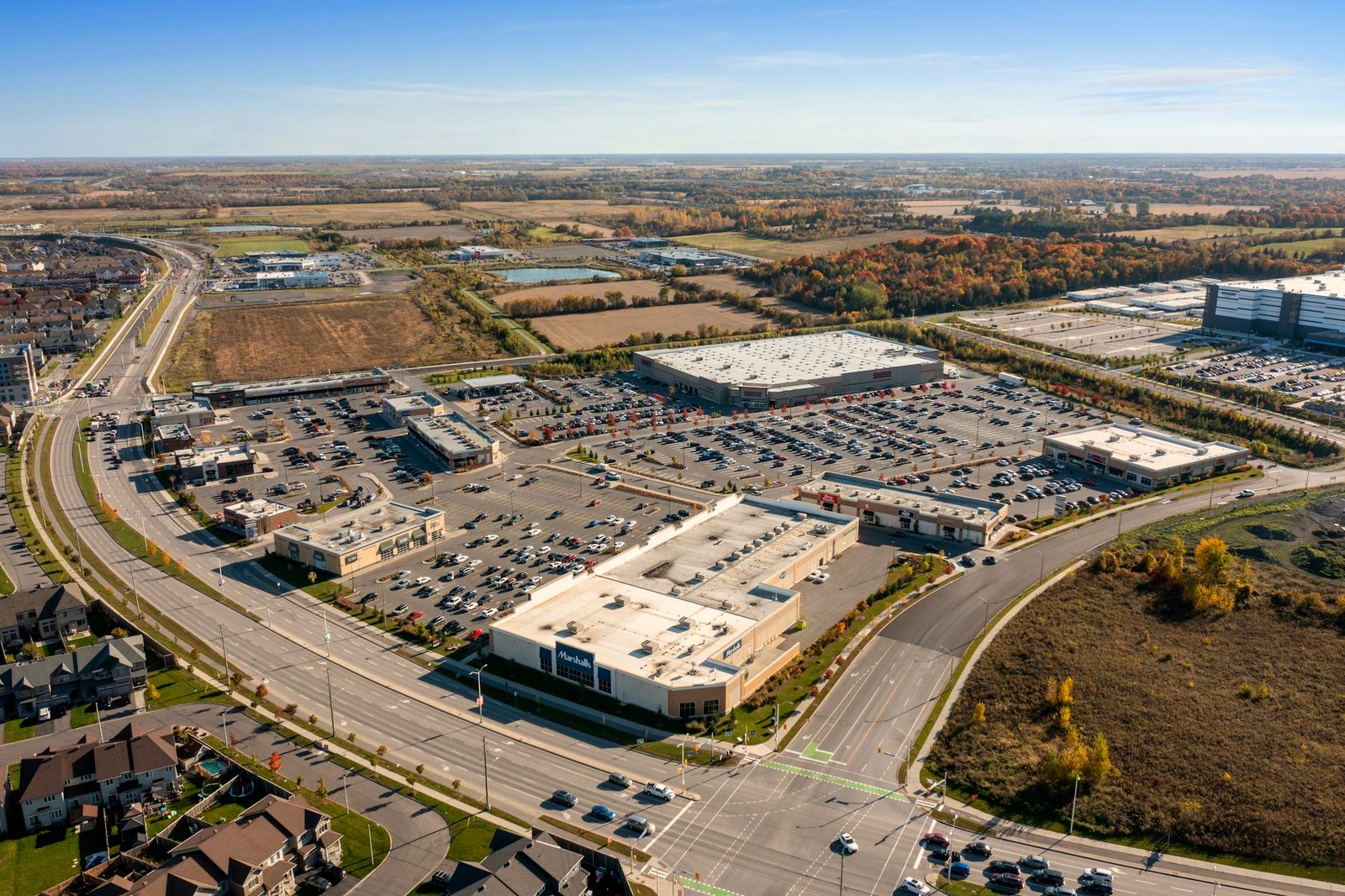 Aerial drone view of a large-format retail centre with anchor stores, arterial road frontage and full car park